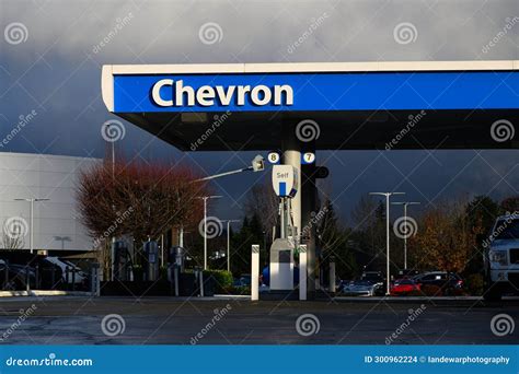 Chevron Sign On Gas Station Awning In Blue And White In Wet Weather Chevron Sign On Gas Station Awning In Blue And White In Wet Weather